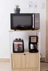 a microwave and a toaster oven on a shelf at House Corner in San Pedro Sula