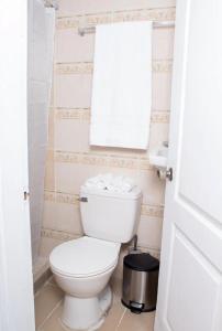 a bathroom with a white toilet and a window at House Corner in San Pedro Sula