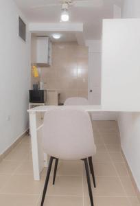 einen weißen Stuhl an einem Tisch in einer Küche in der Unterkunft House Corner in San Pedro Sula