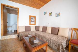 un soggiorno con divano e tavolo di MinoaHouse 1 bedroom,3 guests,bath tub & patio a Ierápetra