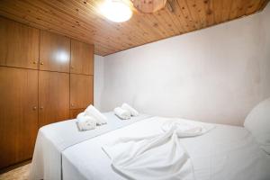 una camera da letto con un letto bianco e asciugamani di MinoaHouse 1 bedroom,3 guests,bath tub & patio a Ierápetra