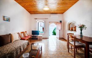 un soggiorno con divano e tavolo di MinoaHouse 1 bedroom,3 guests,bath tub & patio a Ierápetra