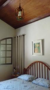 1 dormitorio con 1 cama con techo de madera en Pousada Quinta Bela Vista - Raízes, en Caeté