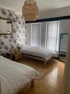 sypialnia z 2 łóżkami i lustrem na ścianie w obiekcie Home Away From Home 家外之家 D w mieście Belfast