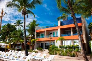 a hotel on the beach with chairs and palm trees at Pousada Bahia Tambor in Morro de São Paulo