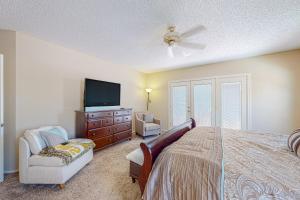 een slaapkamer met een bed, een tv en een stoel bij Sunshine Retreat in Sun Lakes