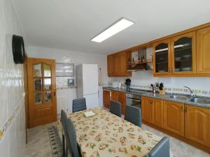 a kitchen with a table and chairs and a kitchen with a white refrigerator at Miradoralaribera Chalet rural in Alcoba de la Ribera