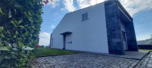 a white building with a door on the side of it at Vivenda Moura, Caloura in Caloura