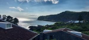 a view of a body of water with houses and mountains at Vivenda Moura, Caloura in Caloura