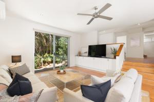 a living room with white furniture and a flat screen tv at Jetty Beach Retreat - Blairgowrie Luxury Family Retreat 5 Bed Heated Pool in Blairgowrie