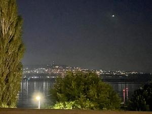 - une vue sur une ville la nuit avec la lune dans l'établissement Seaside Serenity - luxurious beach-front apartment with a refreshing pool, à Varna