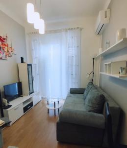 een woonkamer met een bank en een televisie bij Fami Superior One Bedroom Apartment in Rijeka