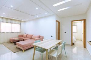 a living room with a pink couch and a table at EL NIDO ALHOCEIMA in Al Hoceïma