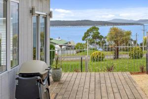 a bike parked on a porch with a view of the water at Cosy Cabin, Big View ! in Primrose Sands