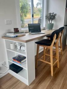 a desk with a laptop and a chair in a room at Cosy Cabin, Big View ! in Primrose Sands