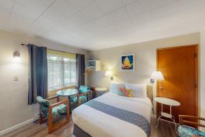 a hotel room with a bed and a window at Lamplighter Inn - Tropical Fish Cove and Octopus Encounter in Bandon