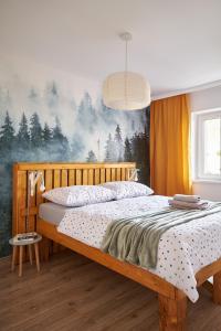 1 dormitorio con cama de madera y mural forestal en LAS I GÓRY Jedlina-Zdrój. Apartament na 5, en Jedlina-Zdrój