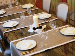 a long table with plates and glasses and a candle at Hotel La Pigna in Marina di Pietrasanta