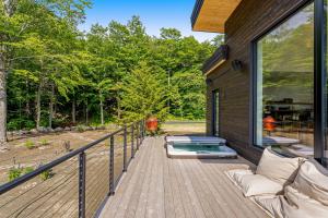 una terraza de madera con bañera de hidromasaje en un lateral de una casa en Sky Zen en Warren