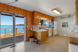 a kitchen with a view of the ocean at Skiou Point Beach House in Tulalip