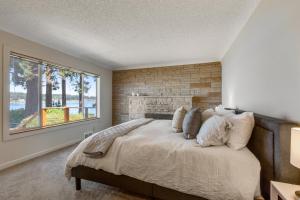 a bedroom with a large bed with a brick wall at Skiou Point Beach House in Tulalip