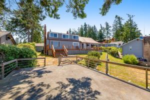 a large house with a fence and a yard at Skiou Point Beach House in Tulalip