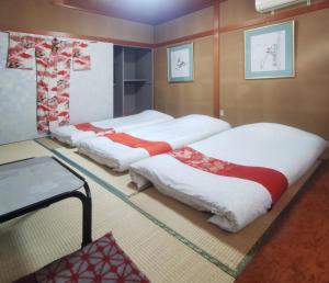 金沢市にある心遊亭Shin Yu Tei 一軒雅宿のベッド2台とテーブルが備わる客室です。