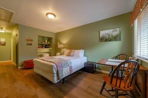 a bedroom with a bed and a table and a desk at Elk Meadow Cabins 11B Roosevelt Elk - Single Room in Orick