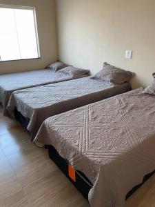 2 Einzelbetten in einem Zimmer mit Fenster in der Unterkunft Rancho do Tomate in São Roque de Minas