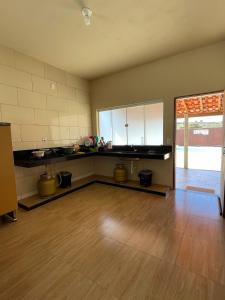 ein leeres Zimmer mit einer Küche und einem Holzboden in der Unterkunft Rancho do Tomate in São Roque de Minas