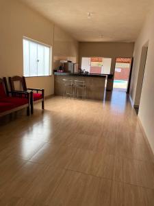 ein Wohnzimmer mit einem roten Sofa und einer Küche in der Unterkunft Rancho do Tomate in São Roque de Minas