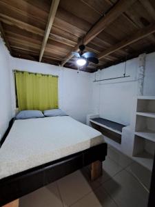 Habitación pequeña con cama y cortina verde en Baconao apartment 1 room, en Puerto Viejo