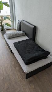 a bed sitting against a wall in a room at SPA-Apartment mit Sauna in Ulm-Böfingen in Ulm