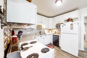 a kitchen with white cabinets and a white refrigerator at Moose Haven in Garden City