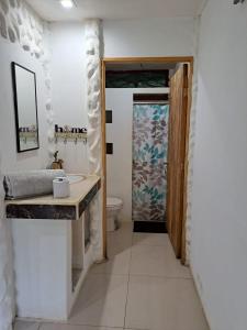 baño con lavabo, aseo y puerta en Baconao apartment 1 room, en Puerto Viejo