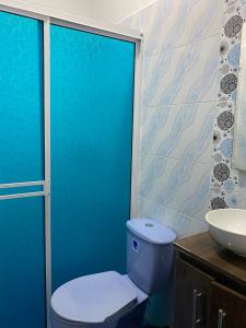 Baño azul con aseo y lavamanos en Sweet Dreams Necocli en Necoclí