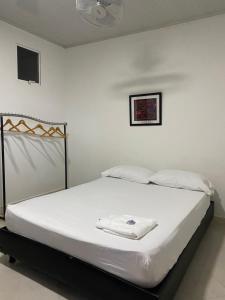 a bedroom with a white bed with a fan at Sweet Dreams Necocli in Necoclí