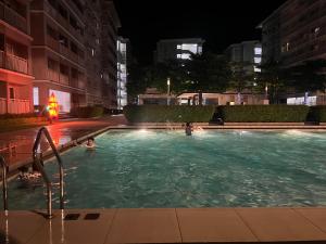 dos personas nadando en una piscina por la noche en Lovers Inn Qc, en Manila