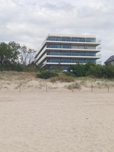 un edificio con una playa frente a él en Apartament Wydma Darłowo Solaris, en Darłowo