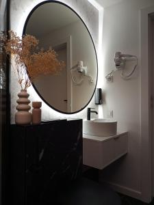 baño con espejo redondo y lavabo en Apartament Wydma Darłowo Solaris, en Darłowo
