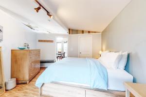 ein Schlafzimmer mit einem weißen Bett und einer Holzkommode in der Unterkunft Evinrude Escape in Coupeville