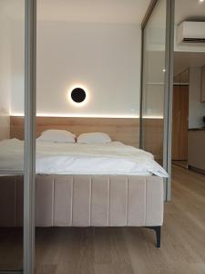 1 dormitorio con 1 cama con espejo grande en Apartament Wydma Darłowo Solaris, en Darłowo