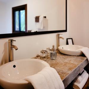 a bathroom with two sinks and a large mirror at Yumas Riverfront Lodge in San Ignacio