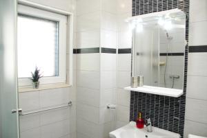 a white bathroom with a sink and a mirror at Beachfront Apartment Nikol in Zaboric +36 photos
