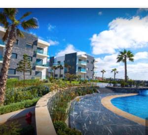 a resort with a swimming pool in front of a building at Appartement pieds dans l’eau Tamaris in Casablanca
