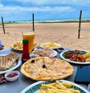 una mesa con platos de comida en una playa en Appartement pieds dans l’eau Tamaris, en Casablanca