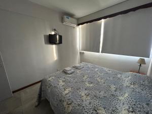 a bedroom with a bed and a tv on the wall at Depto Céntrico a Estrenar con cochera propia in Mendoza