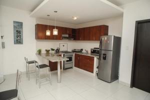 a kitchen with a stainless steel refrigerator and a table at Downtown Apartments "Altos del Sur" in Santa Cruz de la Sierra