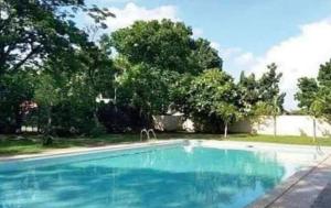 a swimming pool with blue water in a yard at Casa Amelita Malolos in Santa Rita