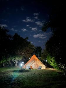 Noonamah的住宿－Noonamah Tourist Park，夜晚坐在田野里的帐篷